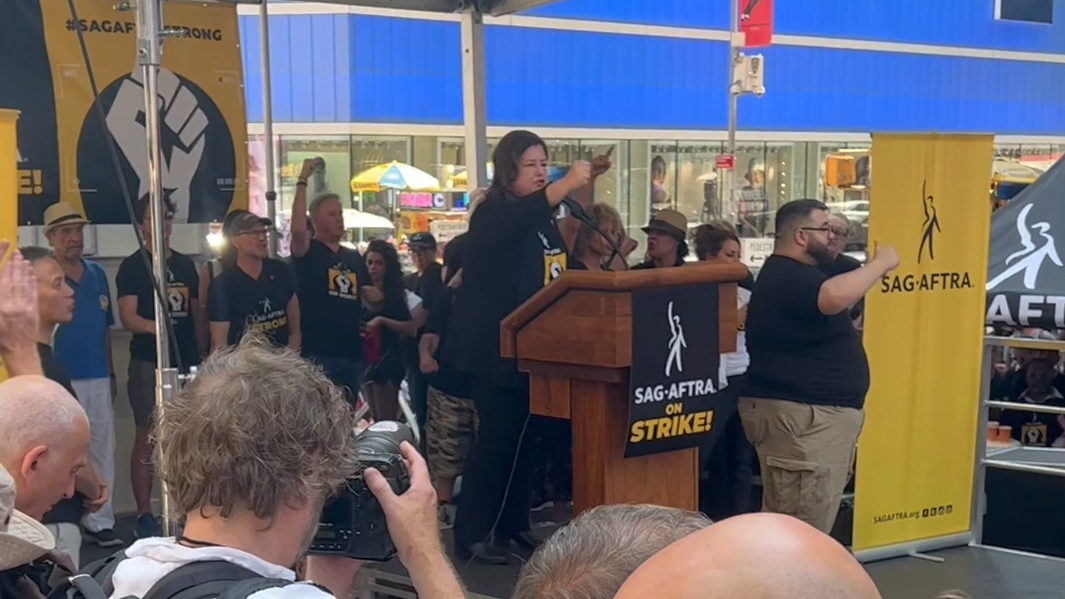 Union leader speaking at the SAG-AFTRA rally in Times Square, advocating for better working conditions and pay.