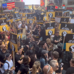Large crowd of SAG-AFTRA supporters holding strike signs in Times Square during the 2023 rally for fair contracts.