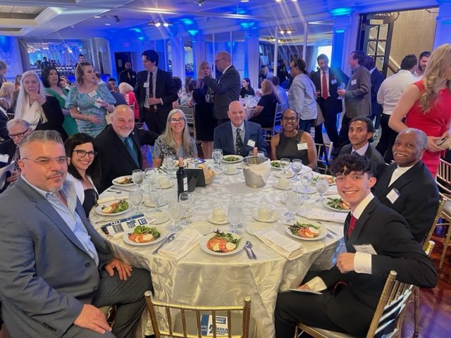 Attendees of the 2023 Press Club of Long Island Media Awards gathered around a table.