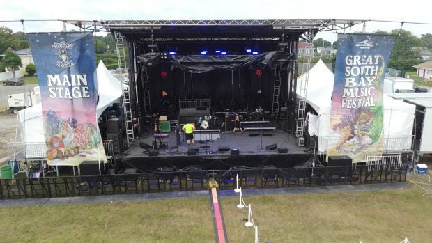 The Voodoo Ranger Main Stage at the Great South Bay Music Festival in Patchogue, NY, with stage setup in progress.