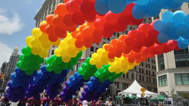 Vibrant rainbow balloons arching over the streets during the 2023 NYC Pride Parade.